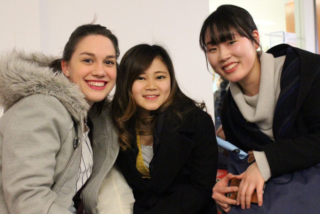 3 English language tutoring students sit together.